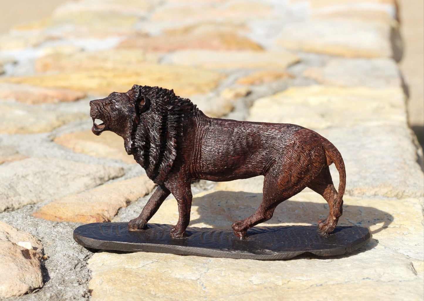 Lebensechtes Meisterwerk aus handgeschnitztem Eisenholz des König der Löwen. Handgefertigte, gehende/brüllende Figur aus Simbabwe, detailreich. Afrikanisches Kunstdekor