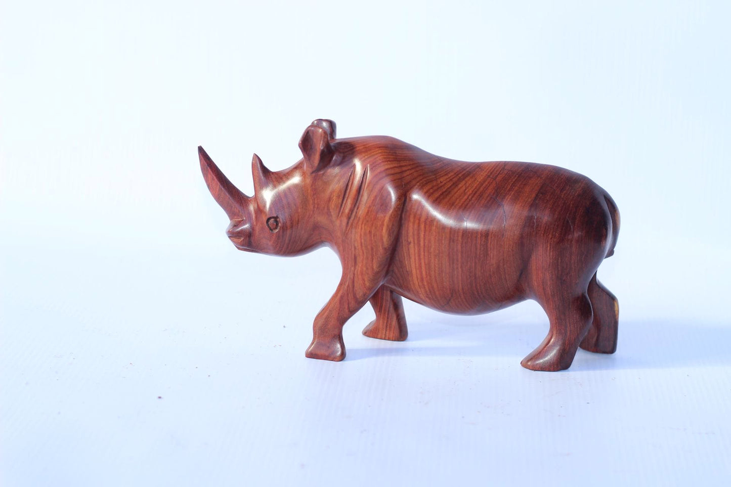 Zambian Teak wood Rhino Sculpture. Handcarved Rhinoceros figurines made from a reddish brown Wood with amazing visible grains. African Decor