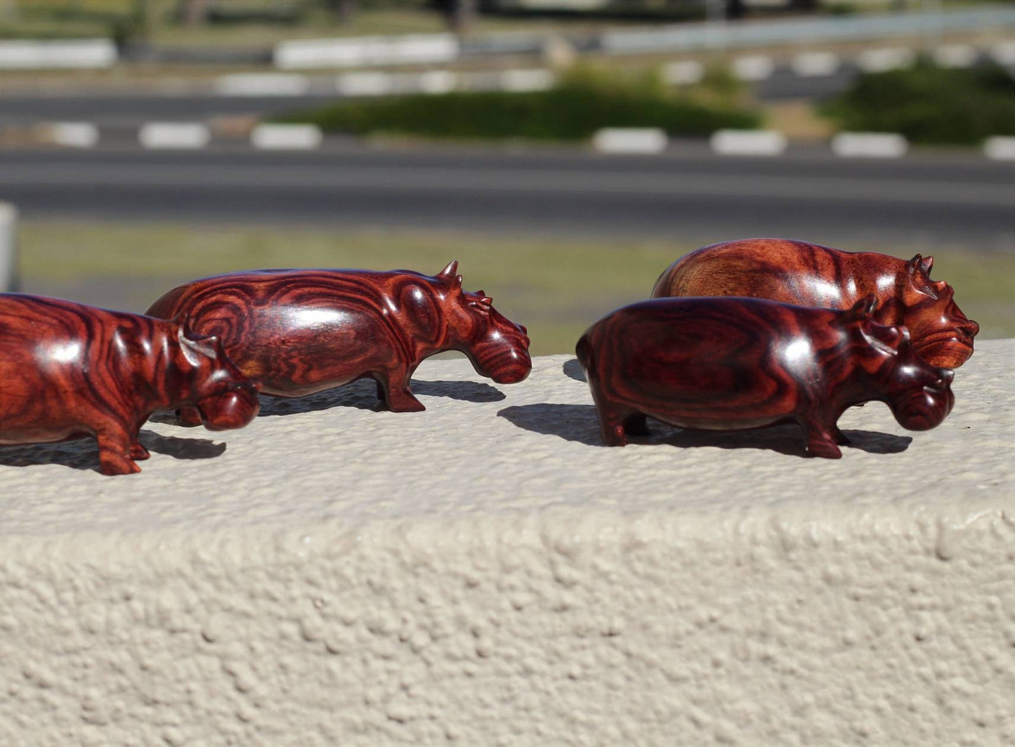 Schule mit 4 aus Zebraholz geschnitzten Mini-Nilpferdfiguren. Handgefertigte afrikanische Kunstskulpturen. Safari-Dekorationsgeschenke für Zuhause und Büro, versandfertig per Express