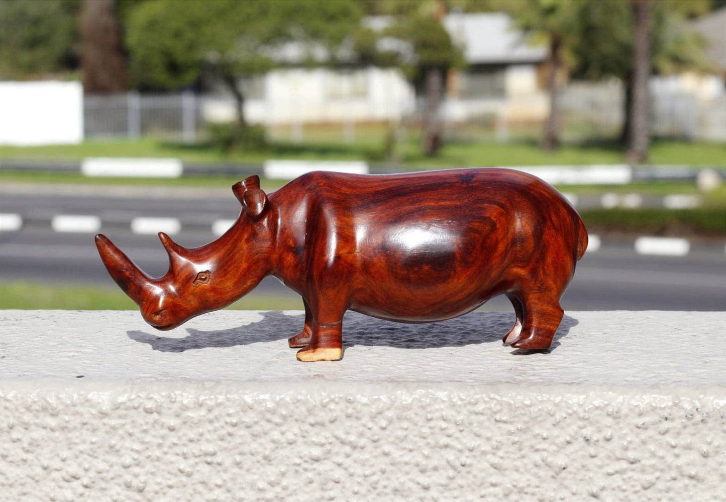 Zambian Teak wood Rhino Sculpture. Handcarved Rhinoceros figurines made from a reddish brown Wood with amazing visible grains. Ships Express