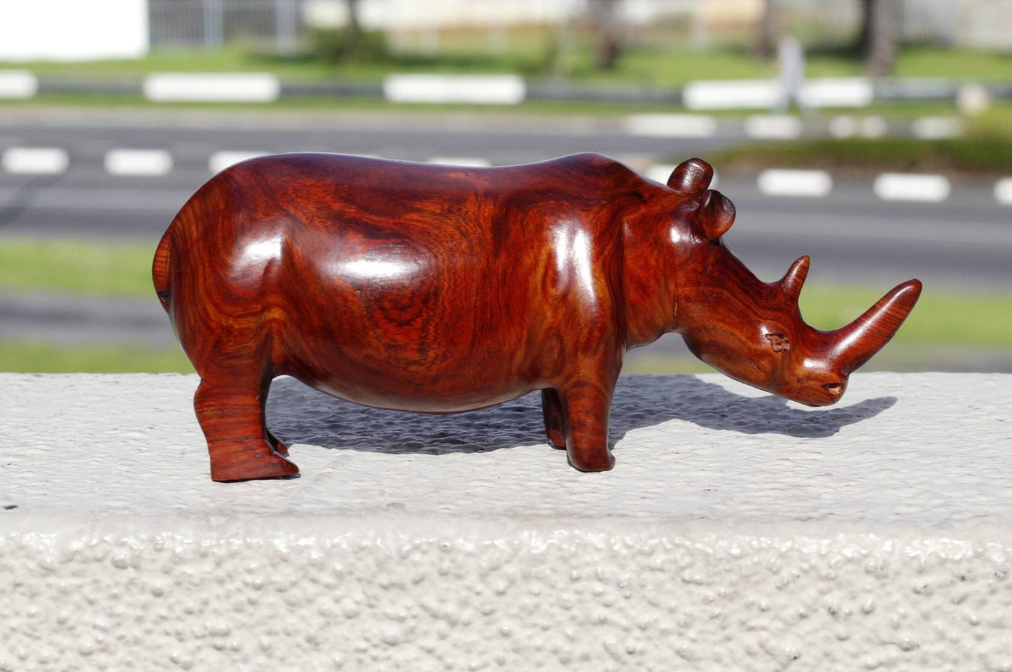 Zambian Teak wood Rhino Sculpture. Handcarved Rhinoceros figurines made from a reddish brown Wood with amazing visible grains. Ships Express