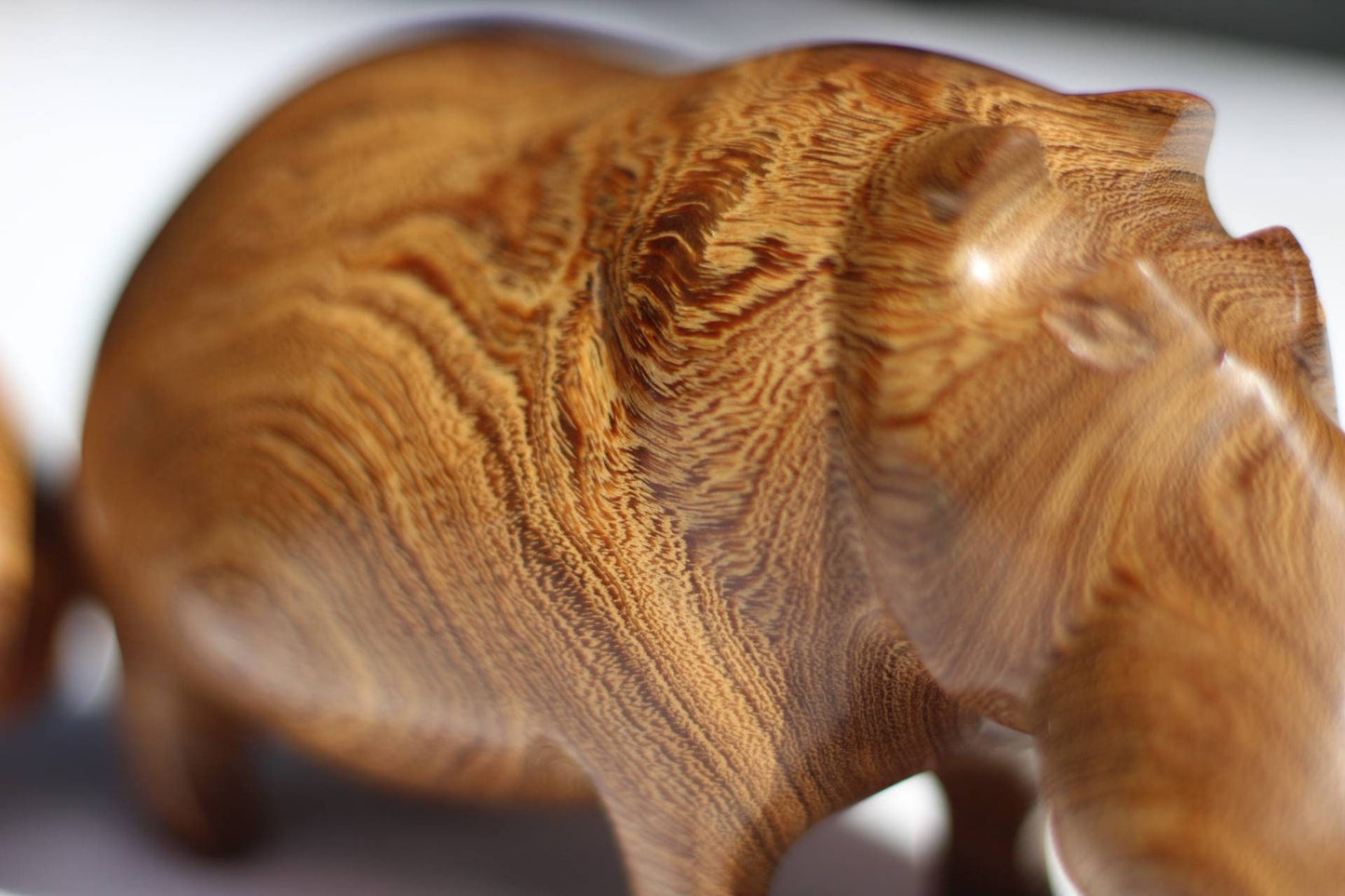 Handgeschnitzte Nilpferdfigur aus Mubanga-Holz. Glatte Safari-Skulpturen aus Sambias Kiaat. Einzigartige Holzmaserung auf einem Stück hellbraunen Hartholzes.
