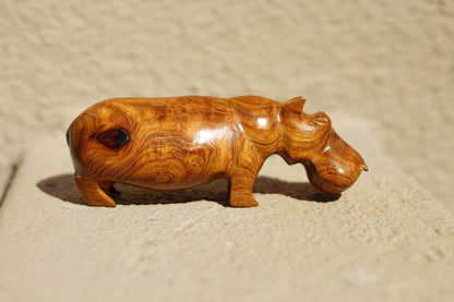 Handgeschnitzte Nilpferdfigur aus Mubanga-Holz. Glatte Safari-Skulpturen aus Sambias Kiaat. Einzigartige Holzmaserung auf einem Stück hellbraunen Hartholzes.