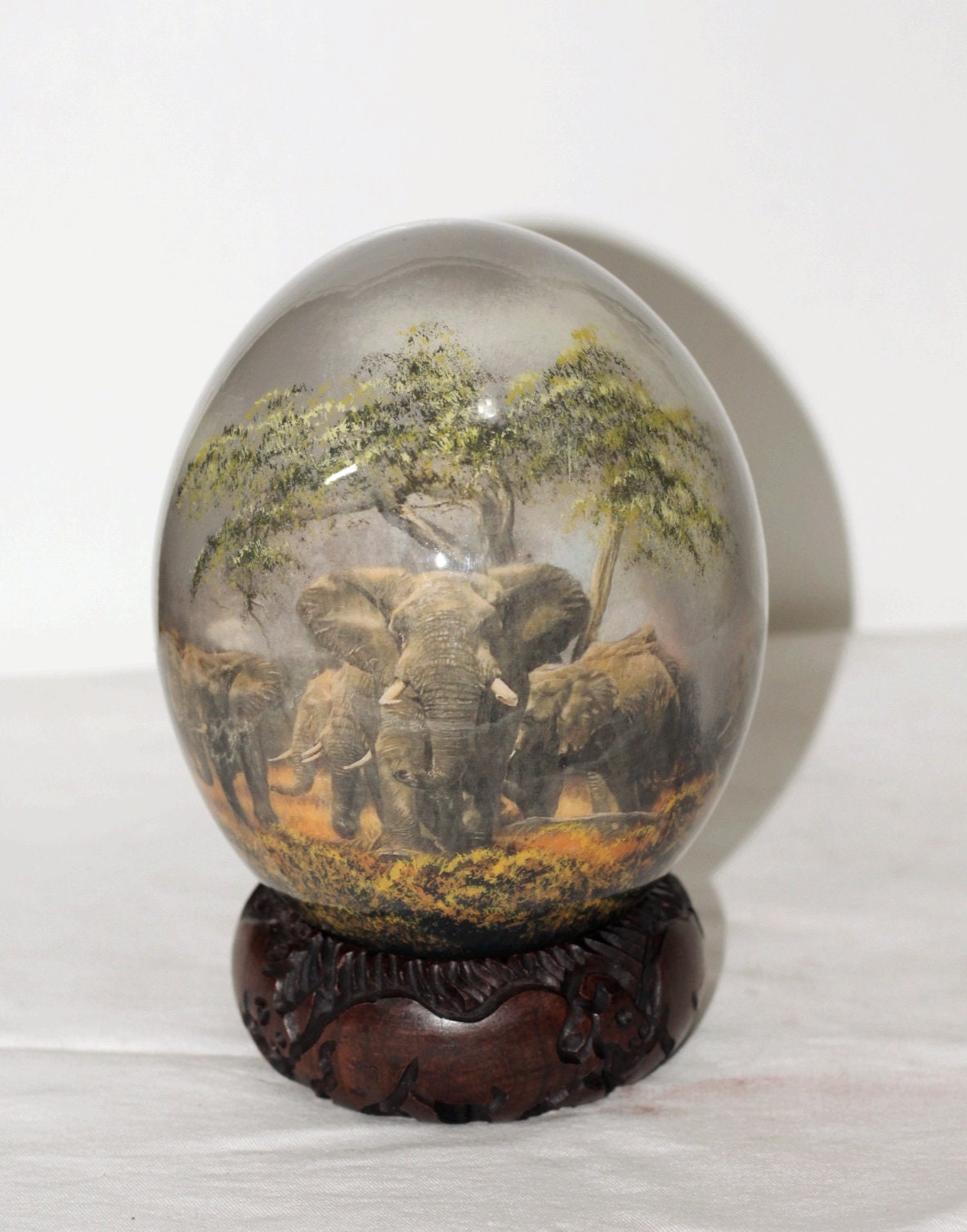 Decoupage Ostrich Egg Elephant Herd on a Gray Forest Background. Comes with a Large beautifully carved Wood stand. Ready to Ship African art