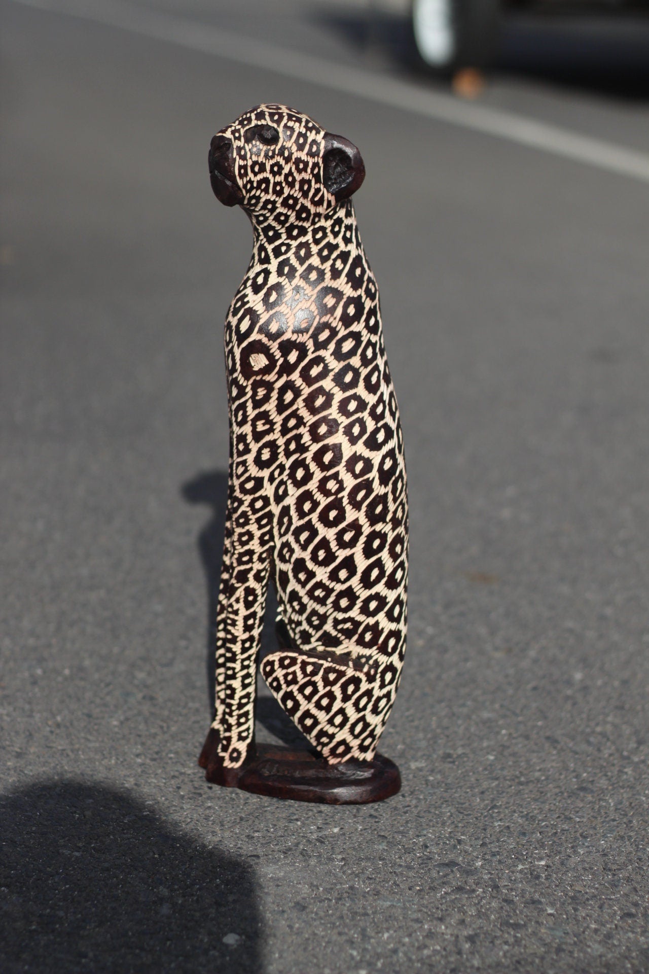 Sitzende Leopardenfiguren. Innen dunkelbraun poliertes und geriffeltes Olivenholz, handgeschnitzte Großkatzenskulpturen. Afrikanische Kunst, Deko-Geschenke.
