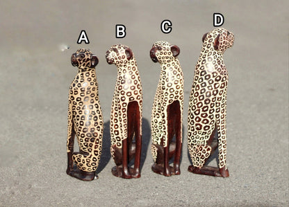 Sitzende Leopardenfiguren. Innen dunkelbraun poliertes und geriffeltes Olivenholz, handgeschnitzte Großkatzenskulpturen. Afrikanische Kunst, Deko-Geschenke.