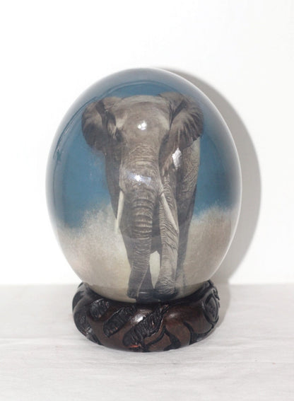 Front view of the Walking Grey Desert Elephant Ostrich Egg Decoupage Art. MmmmSafari art, Home or Office Decor Ornament. Blue background