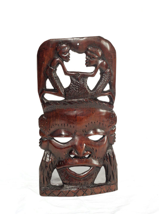 African Man Face Self Standing Mask with villagers performing chores Carvings. Handcarved interior decor tribal art. Brown iron Wood Decor.