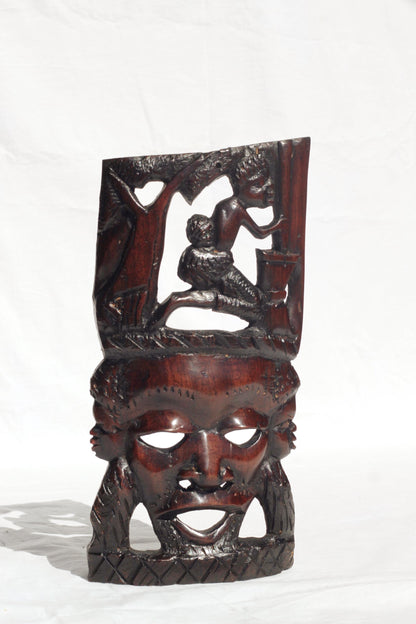 African Man Face Self Standing Mask with villagers performing chores Carvings. Handcarved interior decor tribal art. Brown iron Wood Decor.
