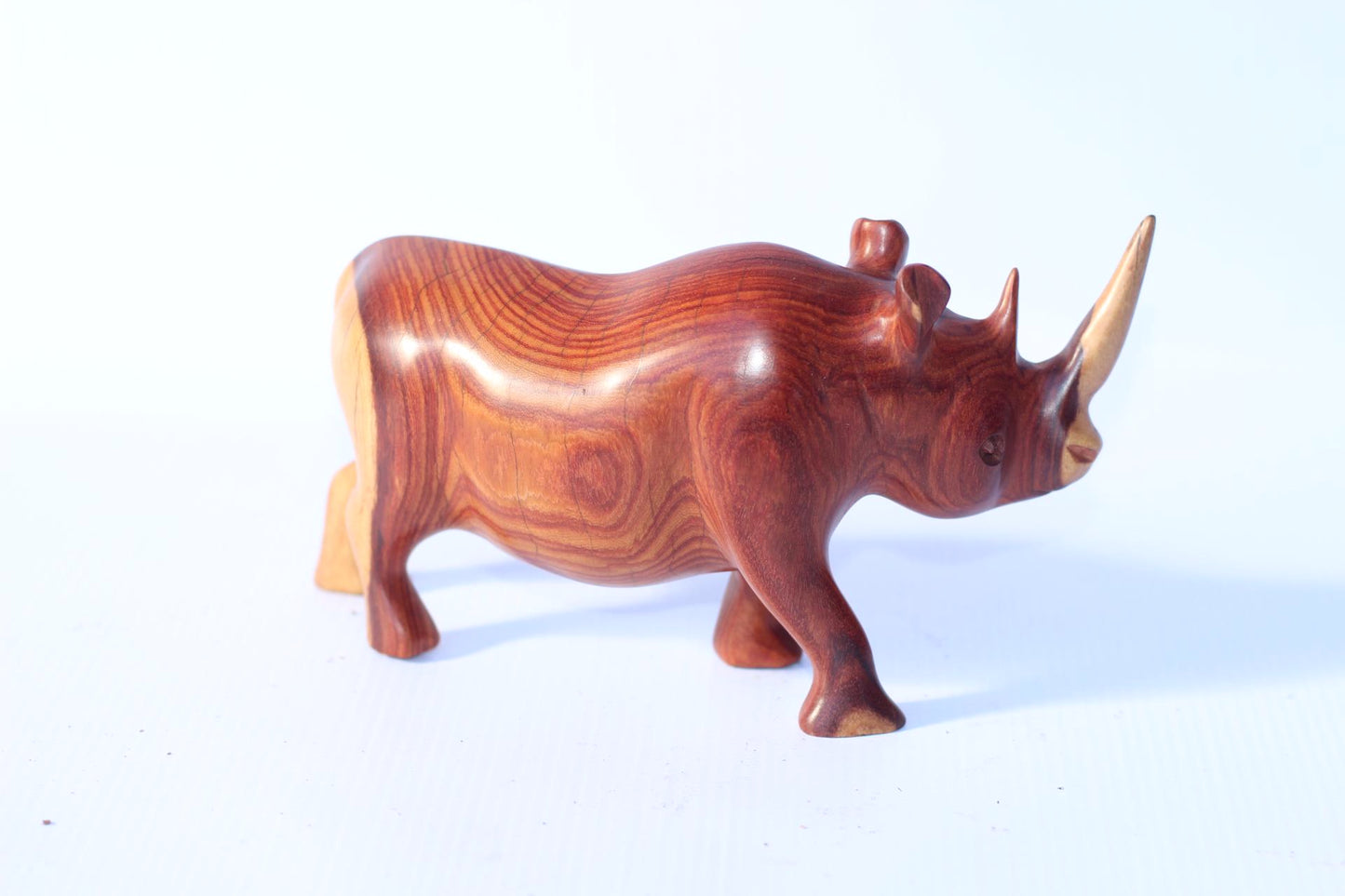 Zambian Teak wood Rhino Sculpture. Handcarved Rhinoceros figurines made from a reddish brown Wood with amazing visible grains. African Decor