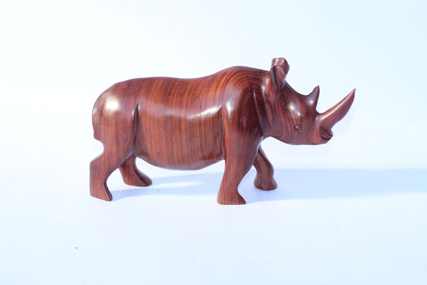 Zambian Teak wood Rhino Sculpture. Handcarved Rhinoceros figurines made from a reddish brown Wood with amazing visible grains. African Decor