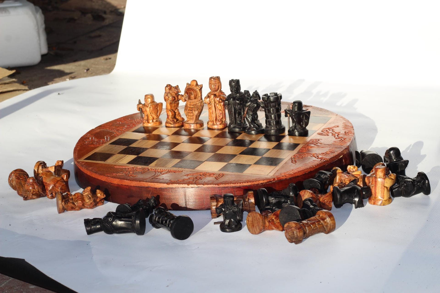 African Hunters Round Foldable Chess Board with Mixed Animal and Warriors Players. Zimbabwean handcarved gaming gift. Olive, Ebony, Mahogany