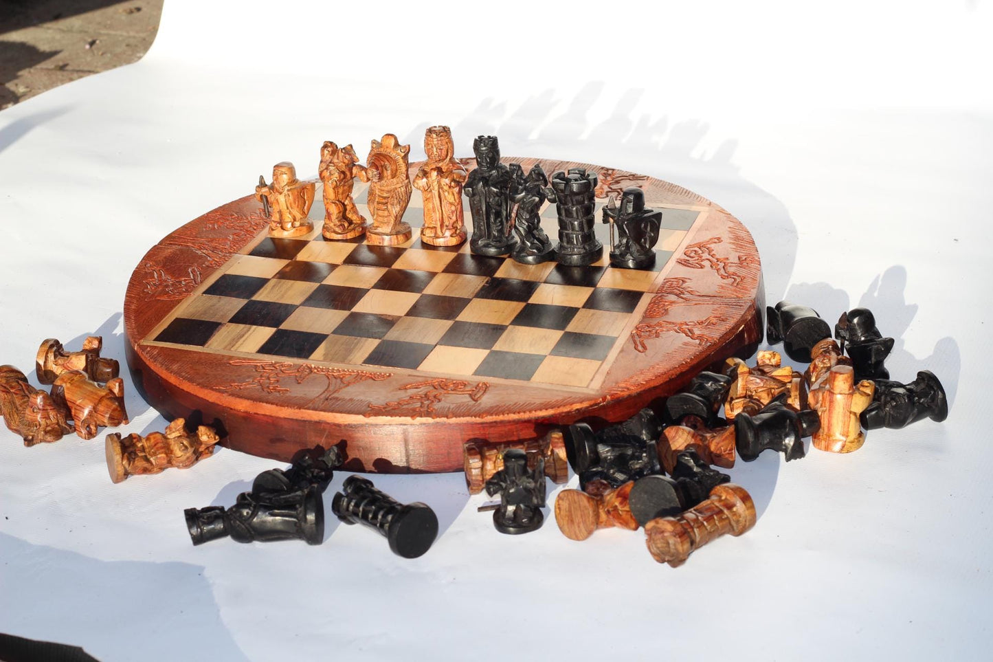 African Hunters Round Foldable Chess Board with Mixed Animal and Warriors Players. Zimbabwean handcarved gaming gift. Olive, Ebony, Mahogany